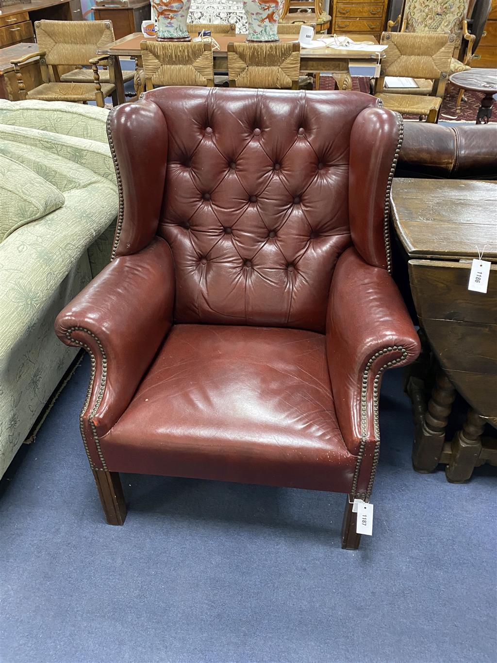 A pair of Chippendale-style buttoned leather wing armchairs, width 82cm, depth 72cm, height 94cm